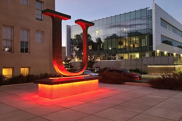 The "U" statue located on main campus UNM in front of Hodgin hall. Pictured is a large statue of the letter U with red up lighting.  